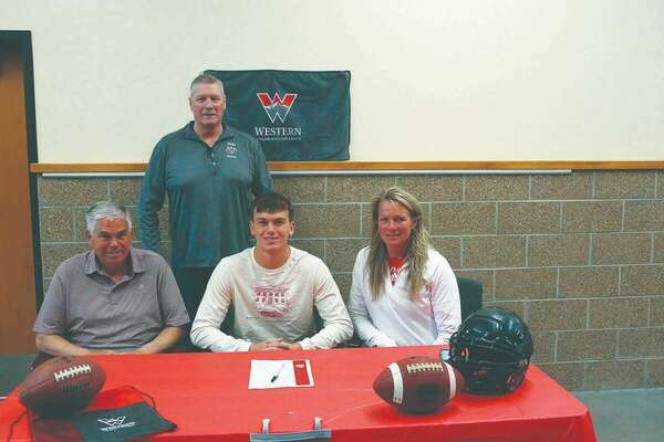 Limon High School senior Treyton Marx signed a letter of intent this week to play football for the Western Colorado University Mountaineers in Gunnison.  Treyton plans to major in Engineering.  Seated with him are his mother and father, Ginger and Dave Marx.  Standing behind him is Coach O’Dwyer.